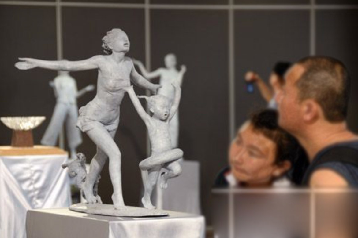 愛好者參觀胡學富雕塑個人展覽的陽光空氣人體雕塑作品