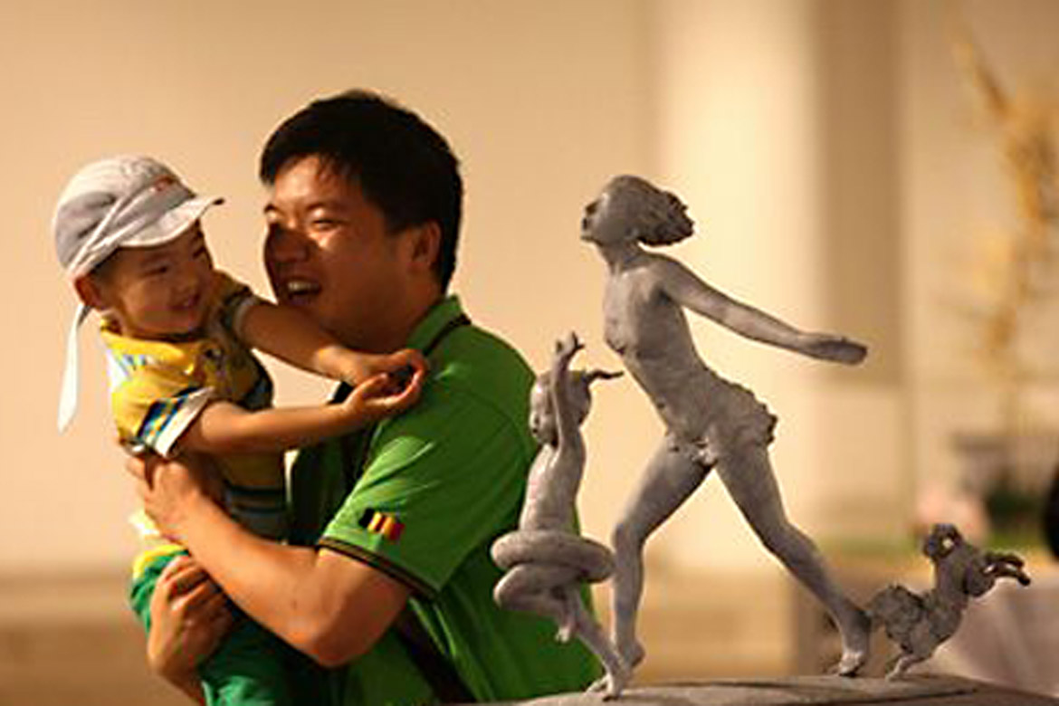 大人抱著小孩欣賞胡學富的雕塑個人展覽人體雕塑作品