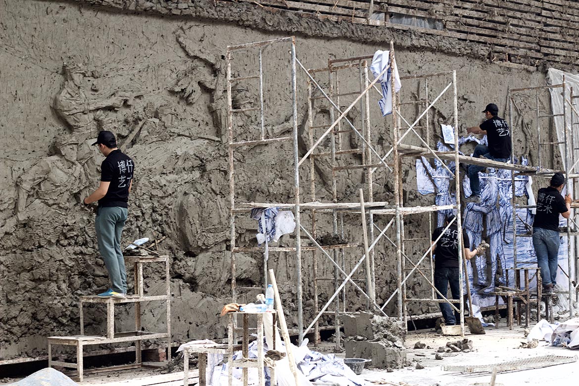 博仟雕塑廠加工人員正在制作大型浮雕泥塑