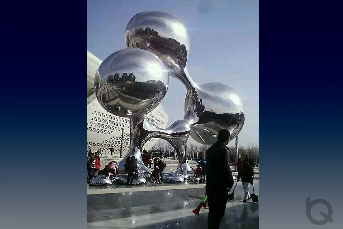 游人在失重不銹鋼水滴雕塑下嬉戲